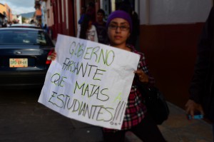 Protester during the march for the 43 disappeared Ayotzinapa students. The sign reads: "Treacherous government, killing your students!" October 2014